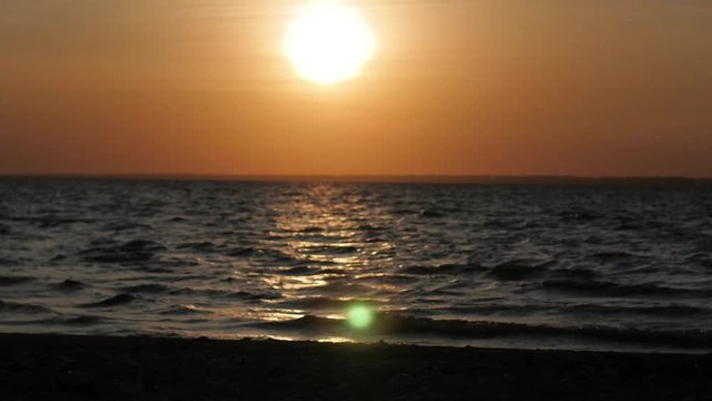 Bright sunset with large yellow sun under the sea surface