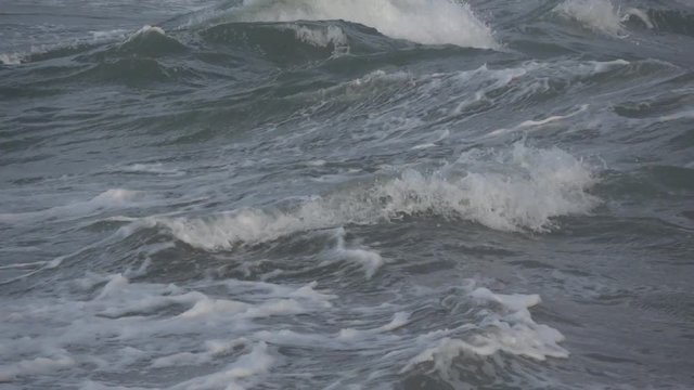 Waves rolling on the beach is a stormy day, winter mediterranean sea. Focene, Lazio, Italy. Slow motion