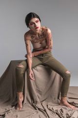 Young brunette cute slim model in skinny jeans leaning forward