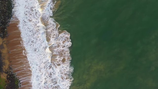 aerial drone footage of a beautiful Sri Lanka coast of empty wild Pitiwella beach with blue turquoise Indian ocean water, big surfing waves, white foam and golden sand