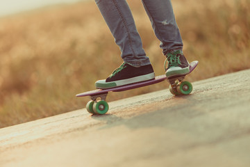 Young happy cute girl rides skateboard on road, outdoor © rimmdream