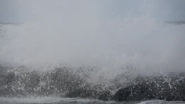 Waves rolling on the beach is a stormy day, winter mediterranean sea. Focene, Lazio, Italy. Slow motion