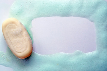 White soap lies on a white table. Frame for an inscription from soap suds. Personal hygiene products.