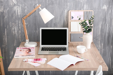 Stylish workplace with modern computer near grey wall