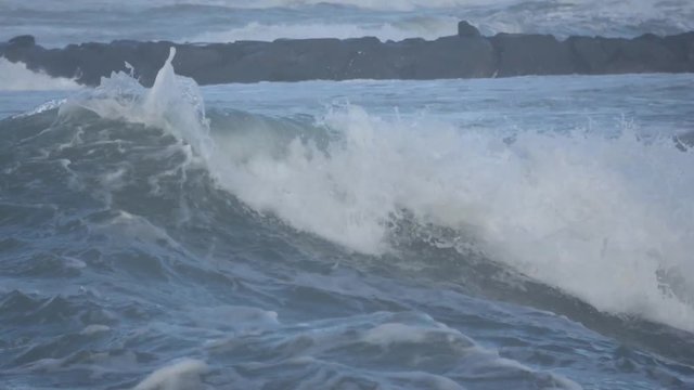 Waves rolling on the beach is a stormy day, winter mediterranean sea. Focene, Lazio, Italy. Slow motion