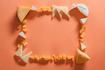 Frame made of assorted tasty cheese on color background