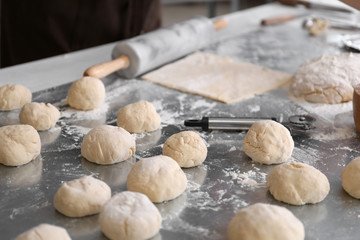 Raw dough for buns on table in kitchen