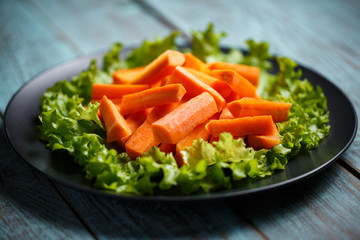 carrot sliced ​​on a plate and wooden background
