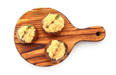 Wooden board with tasty stuffed mushrooms on white background