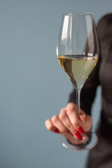 Woman holding a wine glass with wine in hand. Copy space