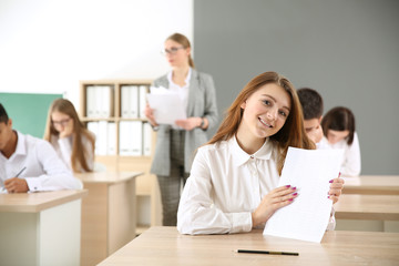 Pupils passing school test in classroom