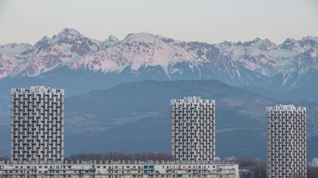 Grenoble, France, Febuary 2019 : timelapse of the sunset on the three towers in front the belledonne mountains, ile verte neighbourhood
