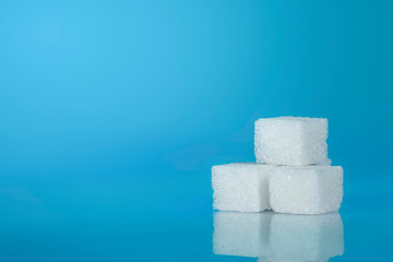 Sugar cubes on light blue background