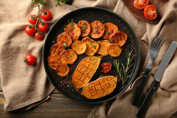 Plate with tasty baked sweet potato on table