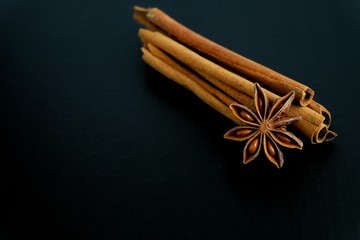 Chinese star anise and cinnamon on black background. 