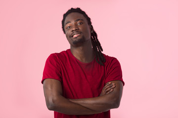 Obraz premium handsome african man with dreadlocks in a red t-shirt on a pink background