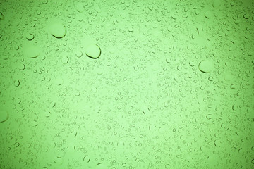 Rain droplets on green glass background, Water drops on green glass.