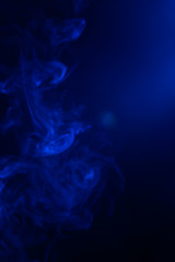 Blue smoke on black background.