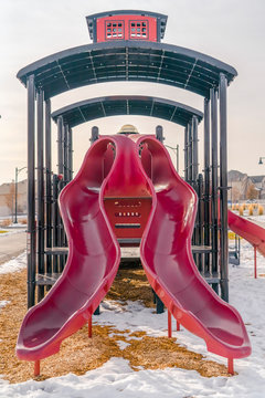 Shiny Red Slides On A Playground In Winter