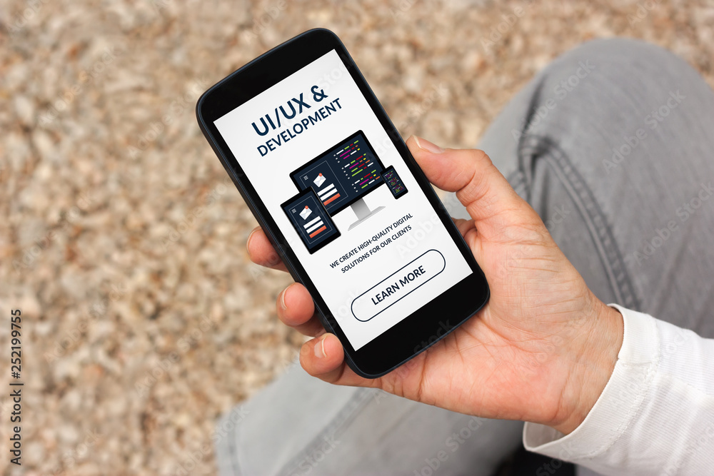 Poster hand holding smart phone with ui/ux design and development concept on screen