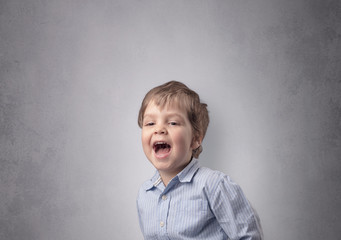 Adorable little boy portrait with empty grey wall background