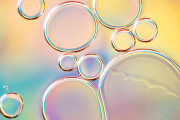 Beautiful macro photo of water droplets in oil with a colorful background.