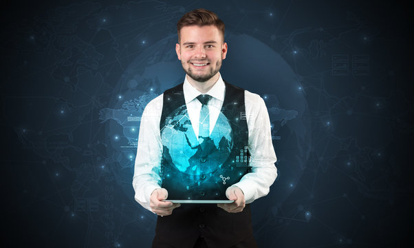 Spectacled businessman with global hologram concept and tablet on his hand
