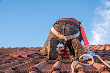 Arbeiter am Dach beim Austausch defekter Dachziegel
