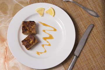 Two pieces of a tuna casserole on a decorated plate.