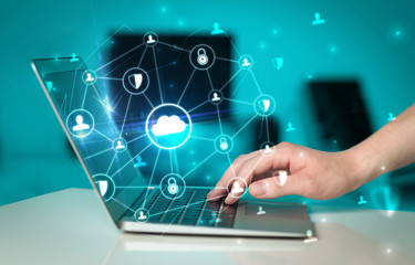 Hand using laptop with centralized cloud computing system and network security concept
