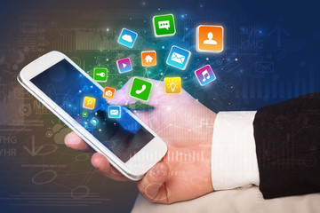 Hand using phone with bouncing colorful application and global reports and graphs concept
