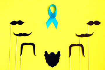 Many black paper Mustache on yellow background. Beard and mustache blue ribbon on yellow...