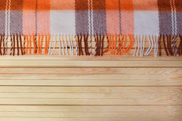 Orange plaid in a cage on a wooden autumn background. Autumn concept. Autumn Time