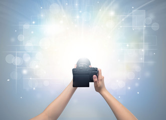 Naked hand taking picture with digital camera and glowing flash concept
