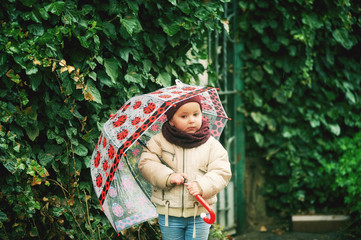 A little girl with an umbrella on a spring walk