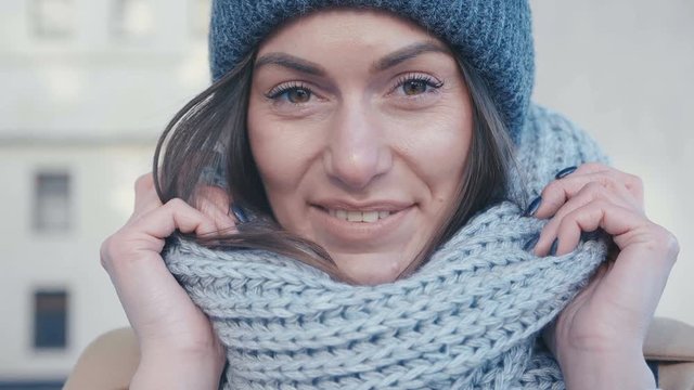 Close-up of a pretty young woman in a hat and scarf cute smiling
