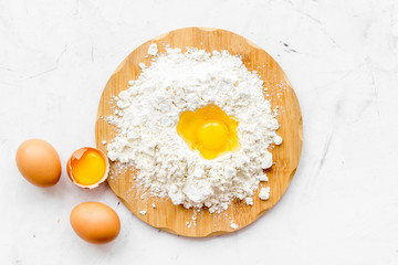 Making dough concept. Pile of flour and eggs on white background top view