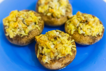 Grilled mushrooms stuffed with cheese on blue plate