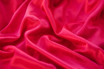 Plakat Close up red fabric. The purple fabric is laid out waves. Pink sateen fabric for background or texture.
