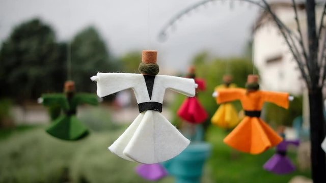 Slow motion of small souvenir figures of dervishes whirling on wind