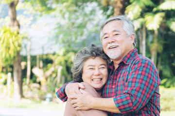 Happy love Elderly couple smile face , Senior couple old man and senior woman relaxing hug in a forest