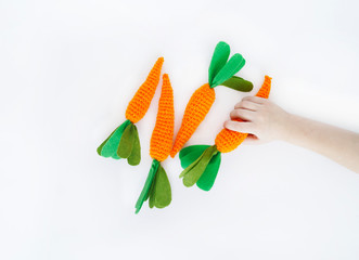 Fototapeta premium Easter. Knitted carrot toy. The process of creating the carrot.