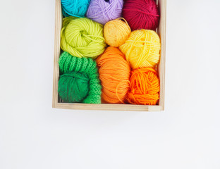 Colorful woolen balls of yarn are in the basket. Needlework. Knitting.