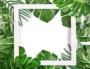 Creative layout made of tropical leaves with vintage frame.