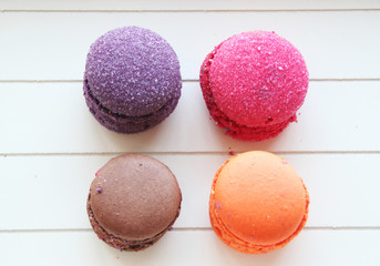 four macaroons of different colors on white background