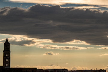 Amazing sky and church silhouette view of ancient town of Matera, the Sassi di Matera, Basilicata, Southern Italy, cloudy summer afternoon just before sunset