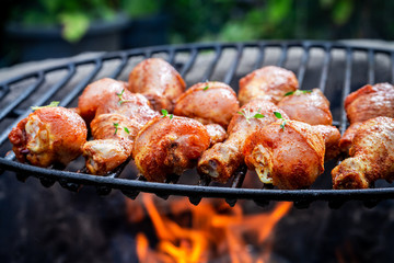 Closeup of chicken leg with herbs on grill