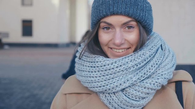Close-up of a pretty young woman in a hat and scarf cute smiling