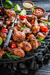 Closeu of spicy grilled chicken leg on metal grate