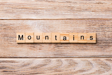 mountains word written on wood block. mountains text on wooden table for your desing, concept